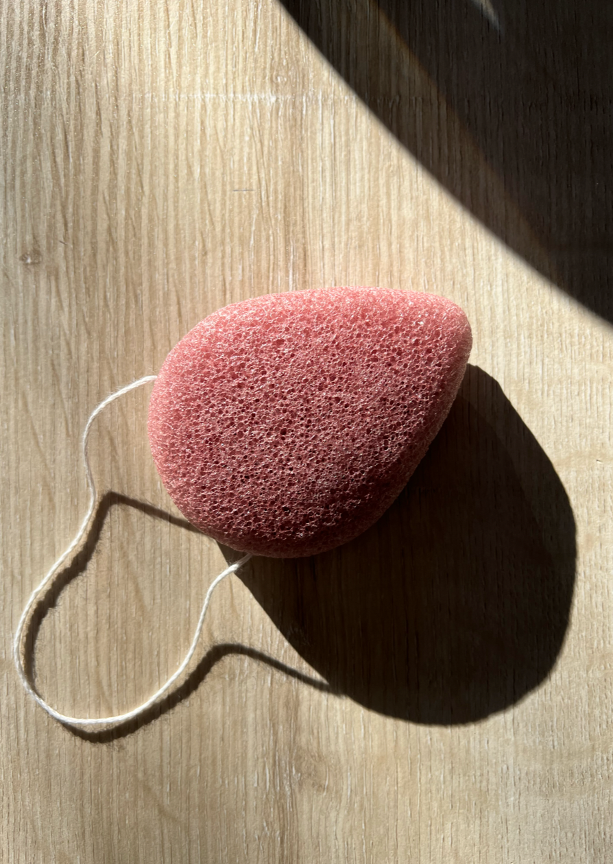French pink clay facial sponge in a dew drop shape